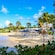 A beach with palm trees, lounge chairs and umbrellas in Saint John’s, Antigua